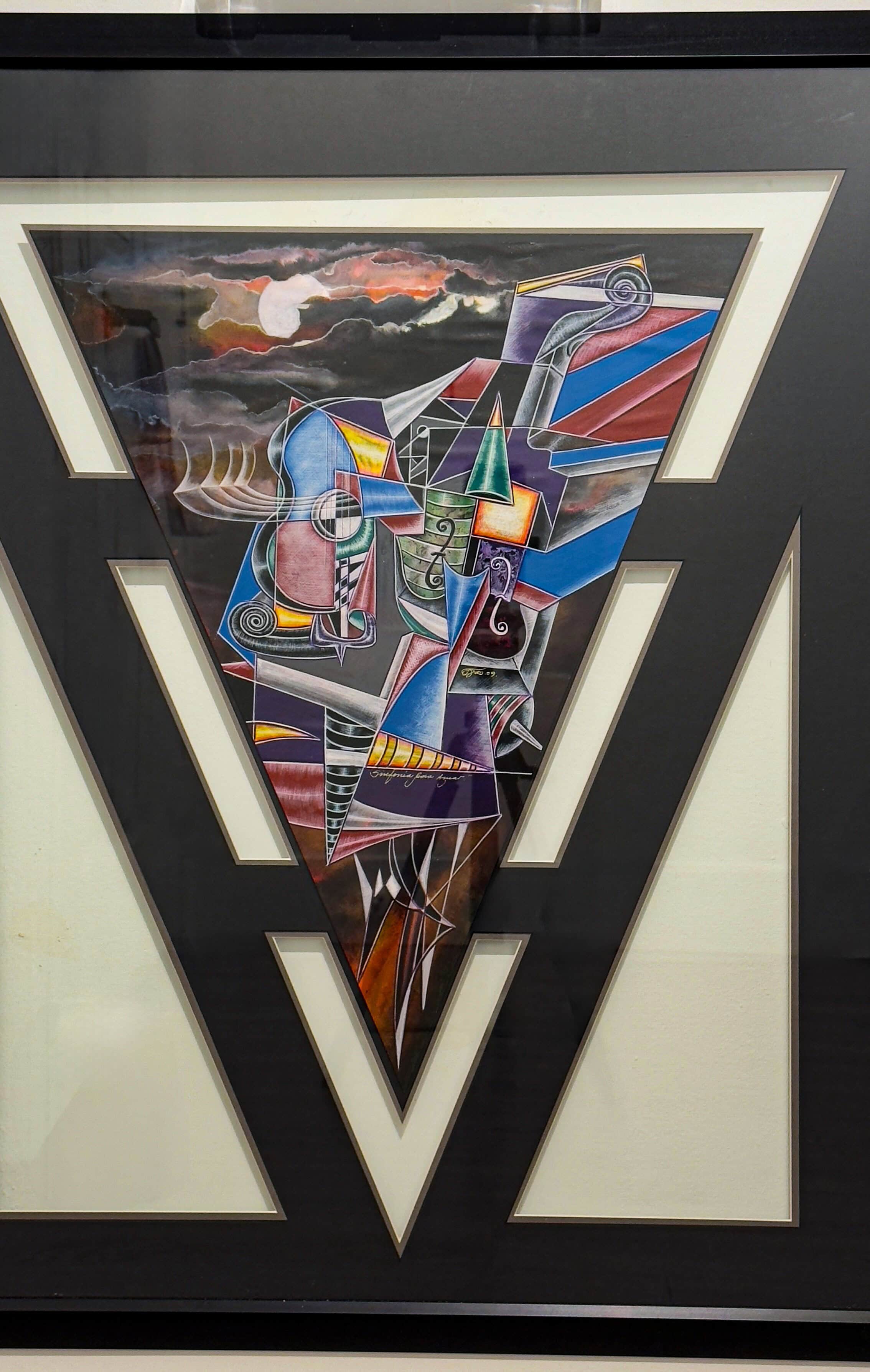 Framed mixed-media watercolor artwork “Sinfonía Para Amor” by Juan Quevedo, featuring geometric abstract forms and vivid colors in a triangular composition.