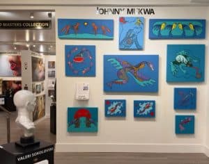Johnny Mukwa Woodland style paintings with animals and symbolic forms in blue background at Vancouver Fine Art Gallery